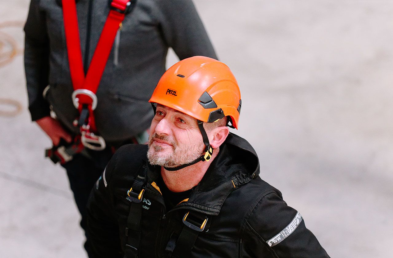 formateur en hauteur avec casque de sécurité orange
