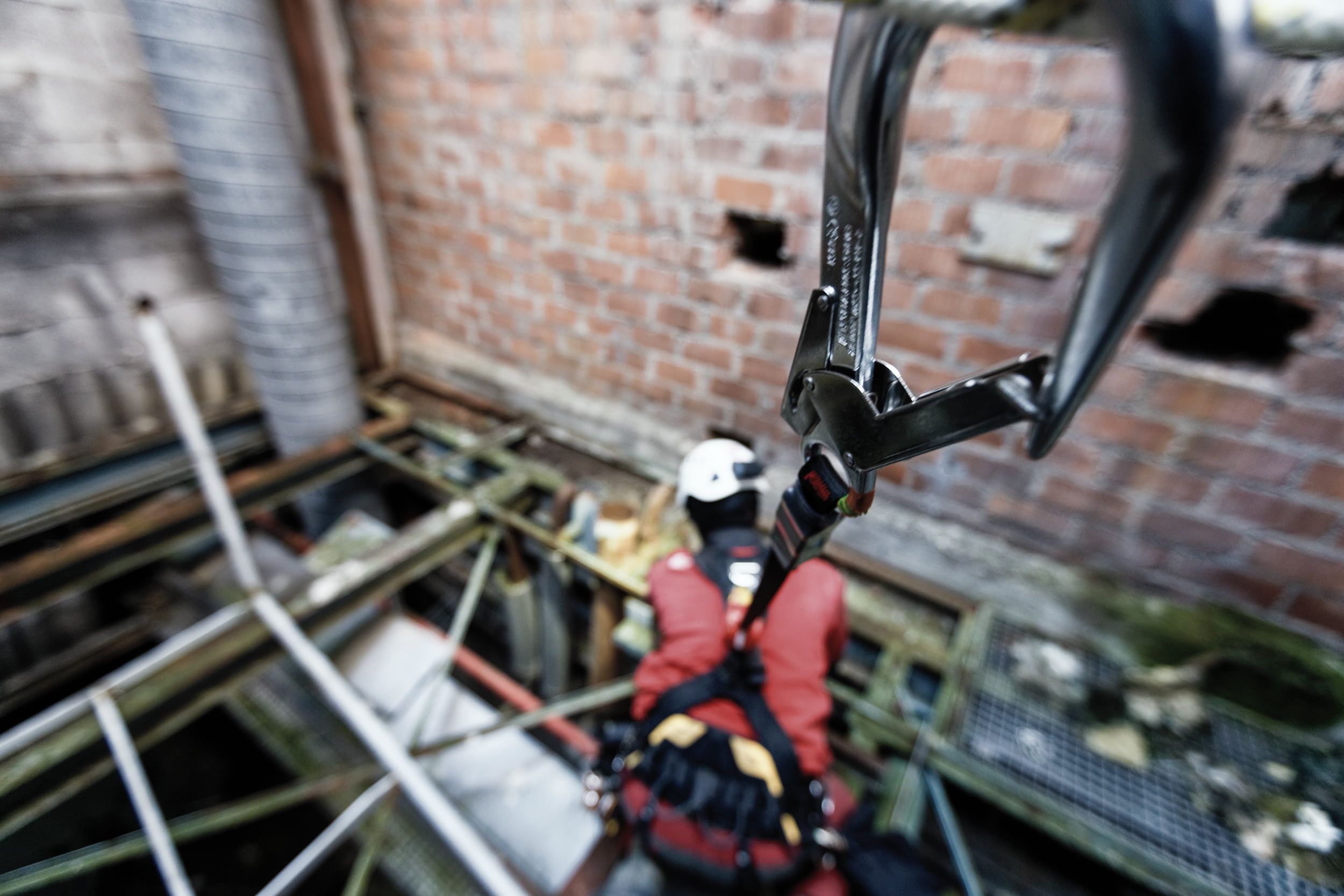 Travailleur en hauteur en formation équipé d’un harnais relié par un enrouleur automatique. 